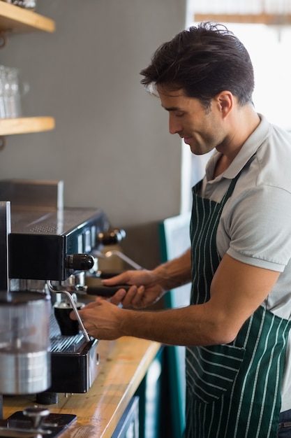 Waiter making cup of coffee