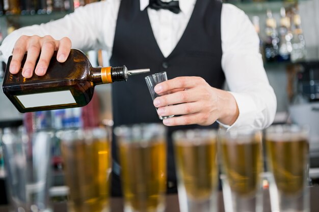 Waiter making shots at bar counter