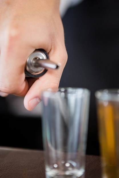 Photo waiter making shots at bar counter