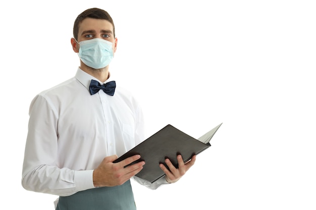 Waiter in mask holds menu, isolated on white background.