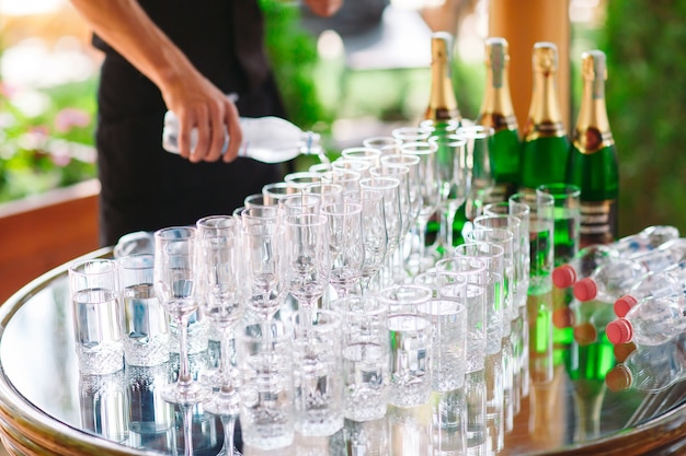 The waiter pours champagne on the buffet table.