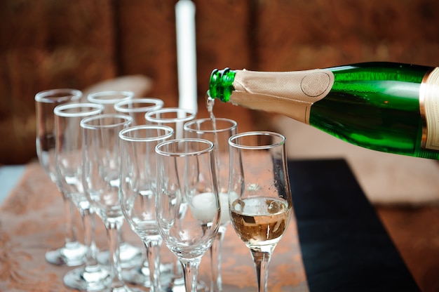 Waiter pours champagne in glasses, luxury event.