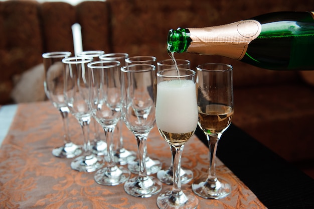 Waiter pours champagne in glasses, luxury event.