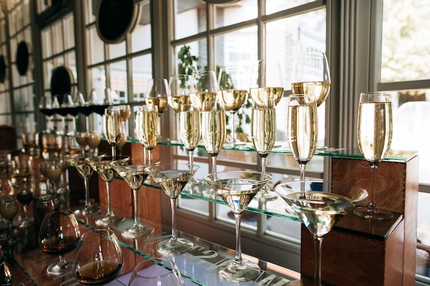 The waiter pours champagne into the glasses at the drink bar