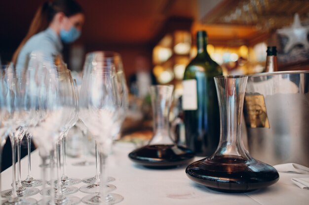 The waiter pours elite red wine into the decanter on the table in the restaurant.