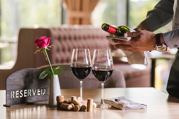 The waiter pours the wine into a glass at the restaurant