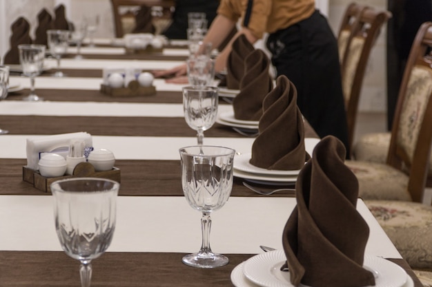 웨이터는 고급 레스토랑에서 연회 테이블을 제공합니다.