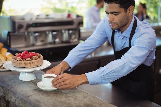 ウェイターがカウンターでコーヒーを提供