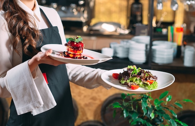 Photo waiter serving in motion on duty in restaurant. the waiter carries dishes