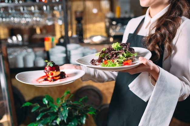 Foto cameriere che serve in movimento in servizio nel ristorante. il cameriere porta i piatti