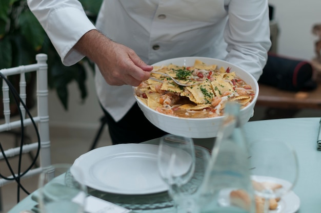 Waiter serving pasta