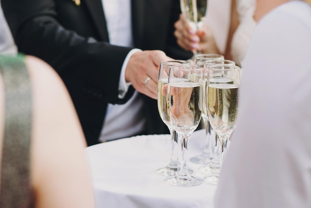 Waiter serving tray with champagne glasses for guests at wedding reception outdoors Luxury life Christmas and New Year feast