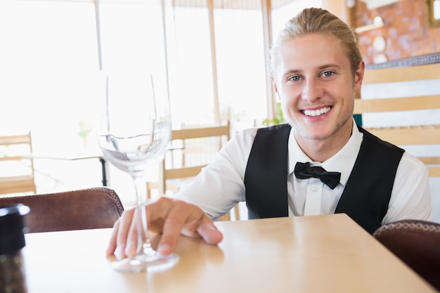 Waiter sitting at table with empty glass