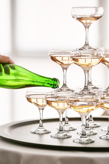 テーブルの上にシャンパンとグラスで作られたボトルとタワーのウェイター