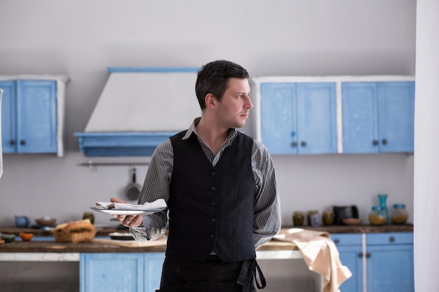 Photo waiter with a plate on a kitchen