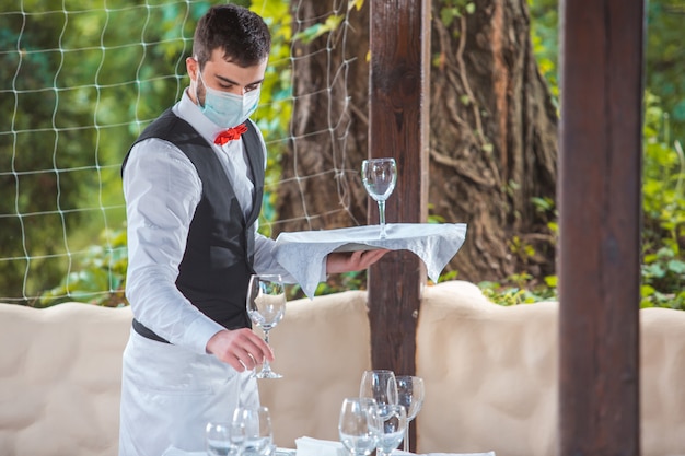 The waiter works in a restaurant on the summer terrace