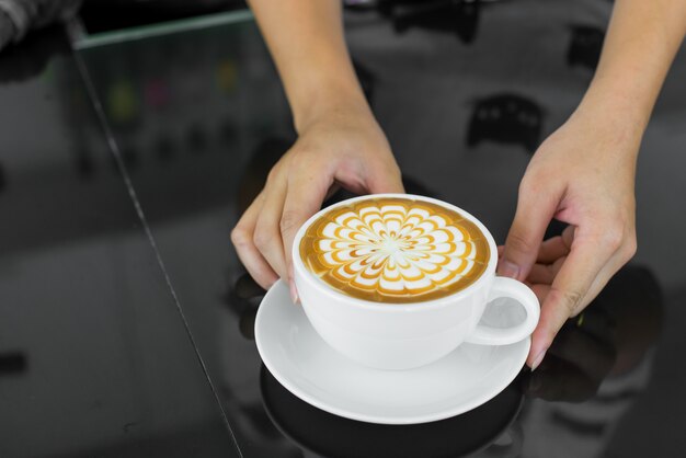 Photo waiters hand gives cappuccino