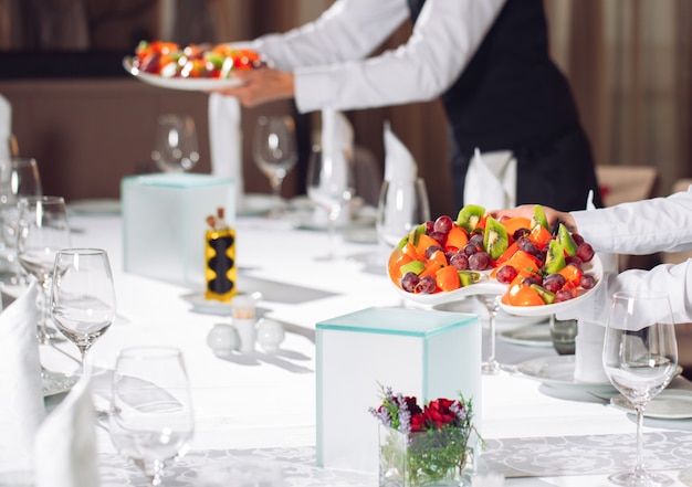 Waiters serving table in the restaurant preparing to receive guests.