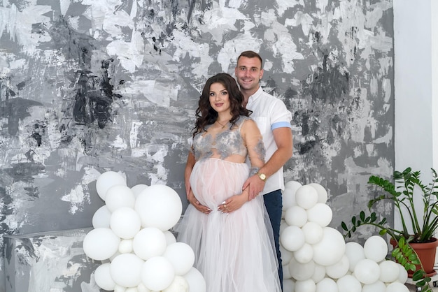 Waiting for a baby. Amazing pair husband and pregnant wife posing in studio