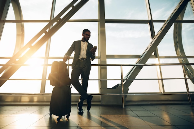 In attesa del volo uomo d'affari con il bagaglio nel terminal dell'aeroporto