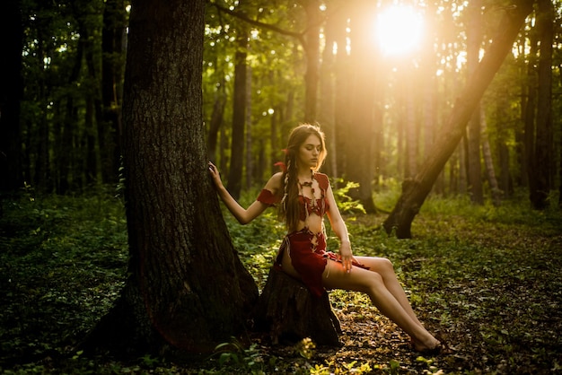 Waiting for him sexy girl in leather suede clothes wild woman in forest amazon woman sexy witch cougar female ethnic tribal fashion deep forest female silhouette through the sun rays