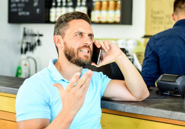 Waiting for you Man mobile conversation cafe barista background Drink coffee while waiting Coffee take away option for busy people Man smartphone order coffee in cafe Coffee break concept