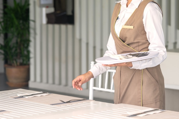 Waitress against empty tableware, table setting. close up