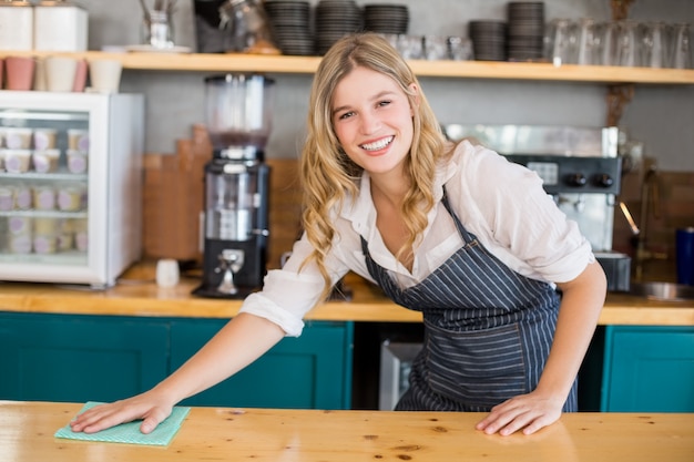 Waitress cleaning cafe counter