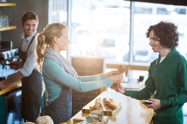 Photo waitress giving parcel to customer at counter