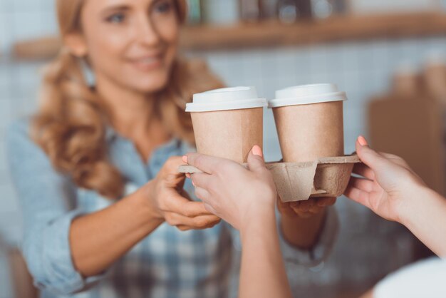 waitress holding disposable coffee cups