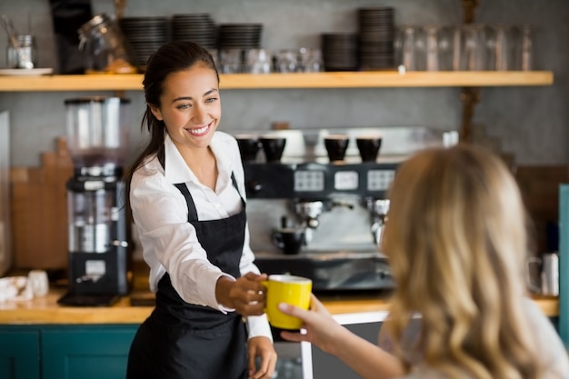 一杯のコーヒーを提供するウェイトレス