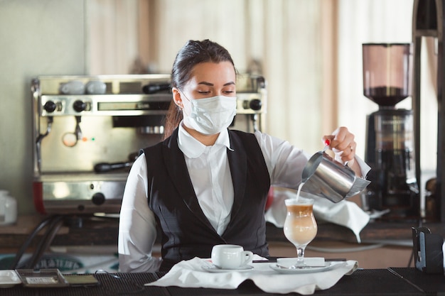 waitress serves coffee latte in a glass