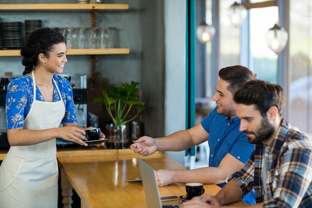 Cameriera che serve una tazza di caffè al cliente