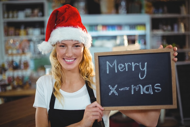  waitress showing chalkboard with merry x-mas sign