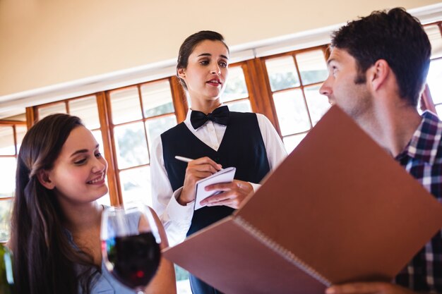 Photo waitress taking an order from a couple