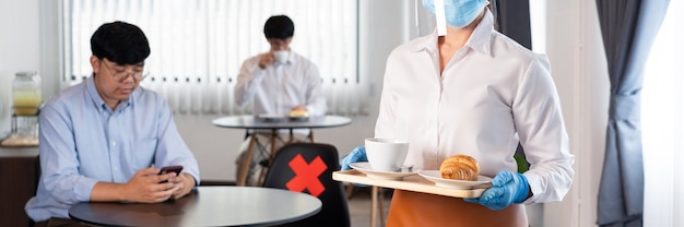 Waitress wearing protective face mask and gloves for outbreak prevention Coronavirus