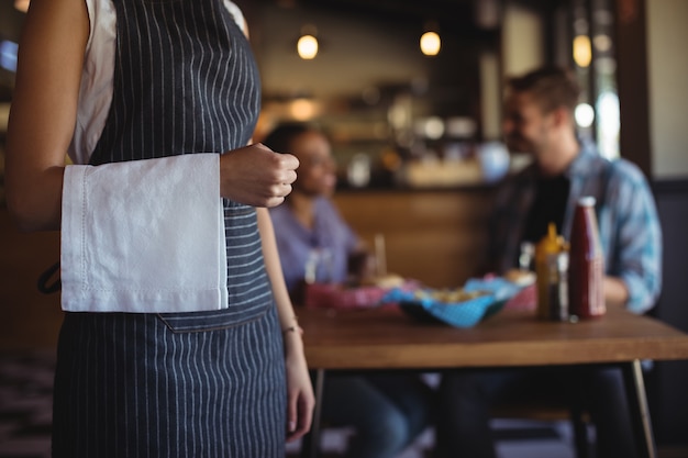 Фото Официантка с салфеткой стоит в ресторане