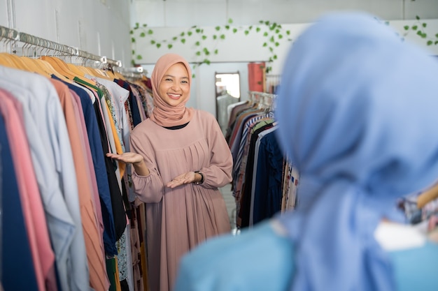 A waitresses in a veil with present hands gesture when the customer arrives