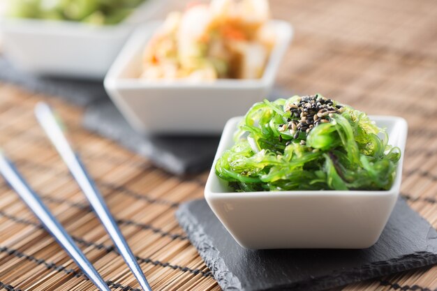 Wakame salade met zeewier en sesamzaadjes op leisteen bord.