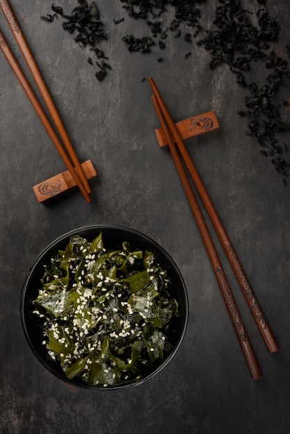 Wakame seaweed salad Bowl and bamboo sticks Oriental serving Top view