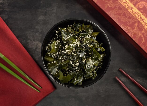 Wakame seaweed salad bowl and bamboo sticks oriental serving\
top view