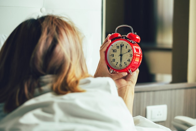 Wake up call.Woman waking up and turning off the alarm clock having a good day