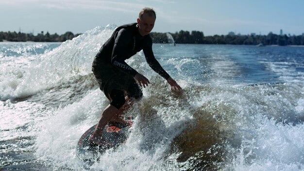 Foto wakesurfer geniet van golven sportman die in slow motion op golven surft