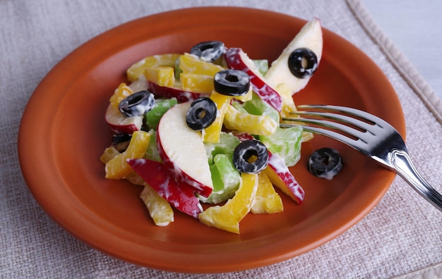 Waldorf salad with olive on plate on table close up