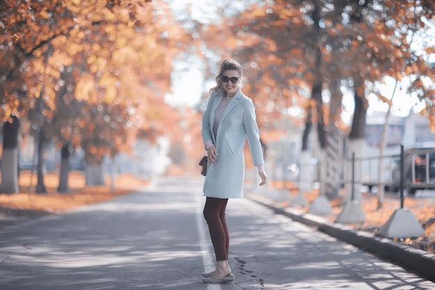 Passeggiata nel parco autunnale / bella ragazza nel parco autunnale, modello femminile di felicità e divertimento tra gli alberi gialli ottobre