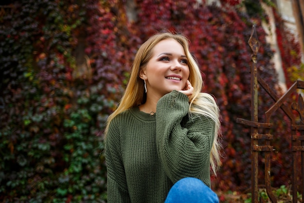 Passeggiata di una bella ragazza in maglione e jeans