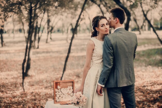 Cammina la sposa e lo sposo nel parco nazionale in autunno.