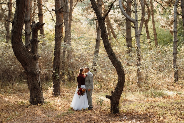 Walk of the bride and groom through the autumn forest in October