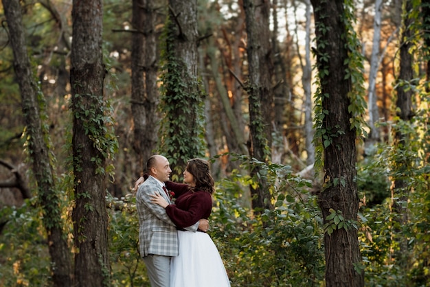 Walk of the bride and groom through the autumn forest in October