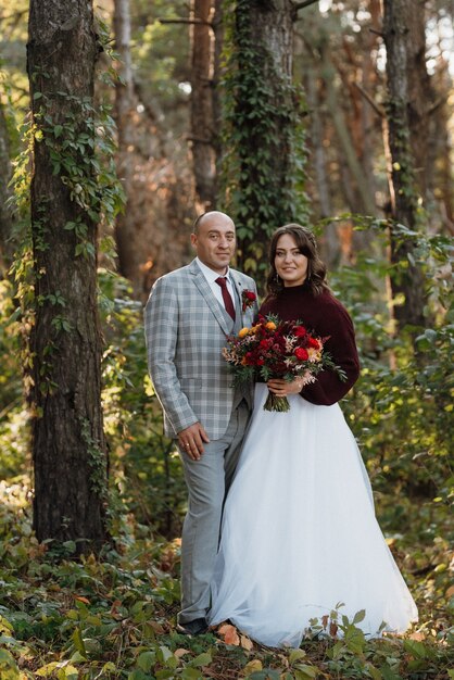 Walk of the bride and groom through the autumn forest in October